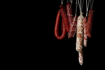 Delicious sausages hanging on dark background