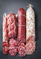 Delicious sliced sausages on dark background