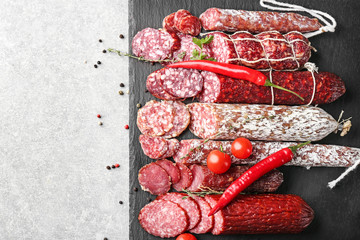 Delicious sliced sausages on slate plate