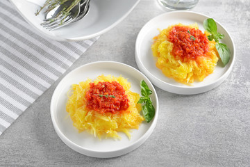Plates with tasty spaghetti squash on table