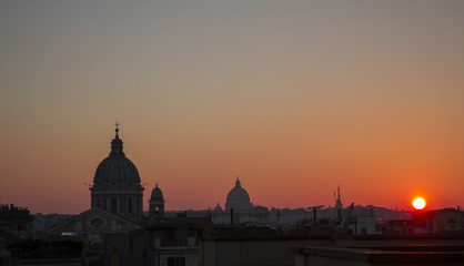 Roman roofs and domes at the sunset / View of Rome cityscape from the roof of so called "Pincio" in Rome, Italy, at sunset, with typical roman roofs and domes