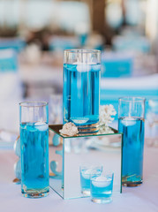 The beautiful wedding hall decorated with a decor in gentle pastel tones from compositions of fresh flowers. Wedding decoration in blue, sea color.