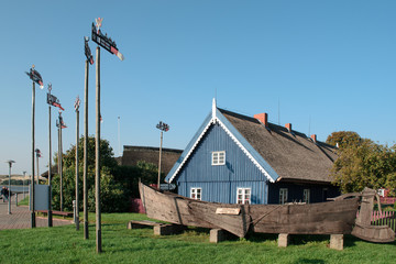 2017-09-23 Nida, Lithuania. Ancient fishing boat and ancient fisherman house in Nida. Lithuania - obrazy, fototapety, plakaty