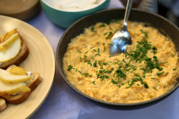 Scrambled eggs with chive in a pan. Selective focus.