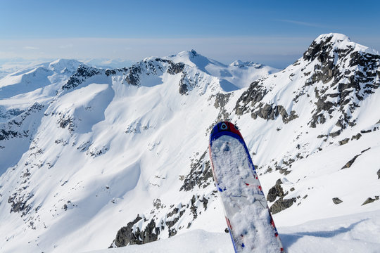A ski on the edge of a steep mountain ready to go