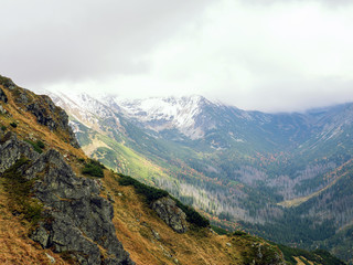 Autumn in the mountains. Snow on tops, bright colors of trees