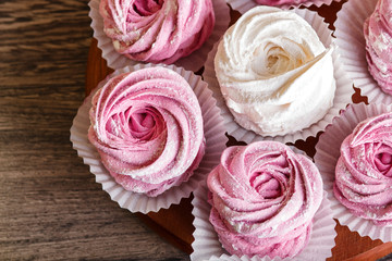  pink and white marshmallows (zephyr) on a round wooden board