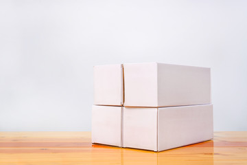 Obraz premium Empty four Package white cardboard box for long items on wooden table with copy space.