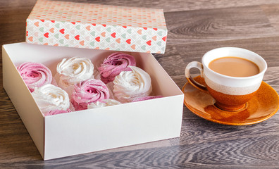 pink and white marshmallows (zephyr) with cup of coffee on a gray wooden background
