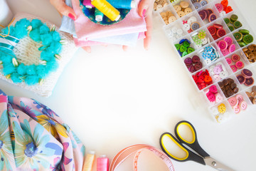 Female hands and accessories for sewing. Buttons, fabric and thread.