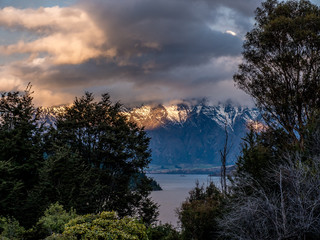 Stormy sunset snow clad mountains Queenstown, New Zealand
