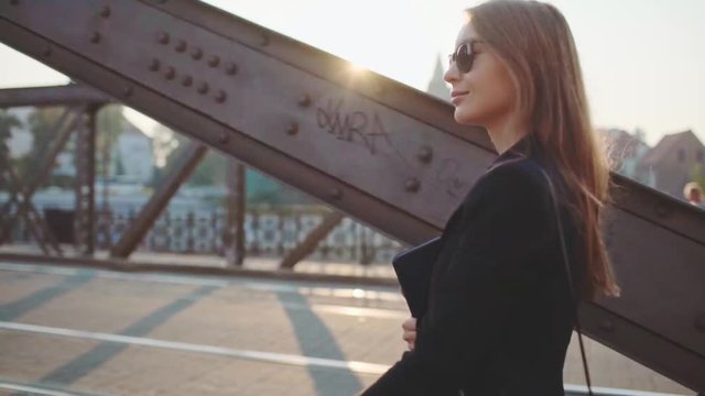 Young Businesswoman Going to Work in the Sunny Morning City. SLOW MOTION. STEADICAM Stabilized Shot. Attractive Professional Business Woman with Tablet rushing to a morning meeting. Lens Flare. 