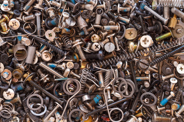 miscellaneous hardware parts including screws washers and springs all jumbled in a pile