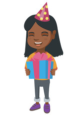 African-american happy smiling girl in birthday cap holding gift box