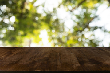 Image of wooden table in front of abstract blurred background of outdoor garden lights. can be used for display or montage your products.Mock up for display of product