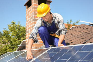 Worker installing solar panels outdoors