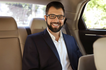 Fototapeta na wymiar Businessman in elegant suit on backseat of car