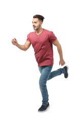 Young man in casual clothes running against white background