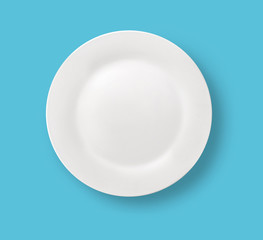 Blank white dinner plate on blue background.