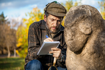 scientist and historian, describes sitting stone sculpture on mound