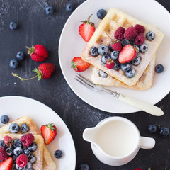 Belgium waffles with fresh berries on white plate. Top view