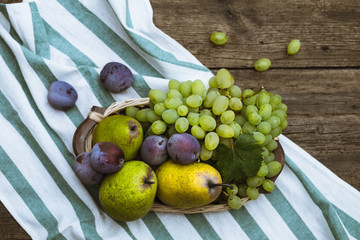 fruit grapes plum pear on wooden background