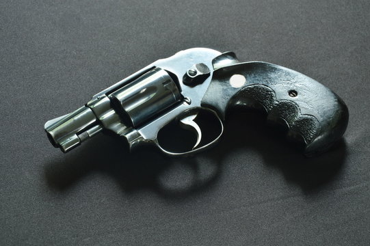revolver gun on black fabric background