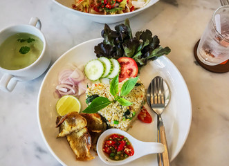 top view of decorative fried rice with crispy fish on white plate in modern restaurant