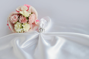 Vintage cutlery with tender bouquet on white silk. Space for text