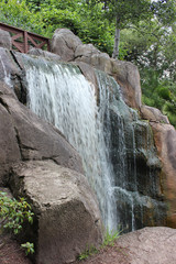 Fototapeta na wymiar Bridge over a small waterfall