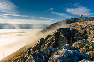 Cloud inversion from a mountain top - beautiful autumn landscape with thick blanket of rolling clouds at sunrise