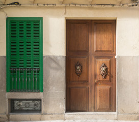 Braune Haustür aus Holz mit grünem Fensterladen