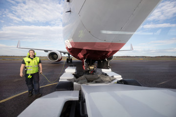 Ground Worker Standing By Aircraft With Communication Cable On R