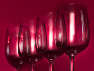 Catering, party concept: wine glasses on a ruby background. Selective focus.