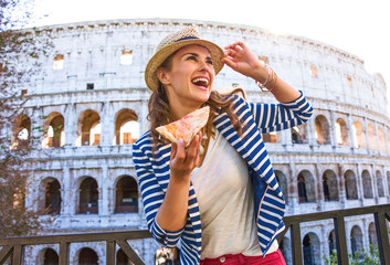 Naklejka premium turystyczna kobieta z plasterkiem pizzy patrząc w dal