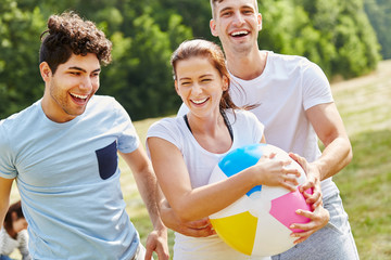 Freunde lachen und spielen mit Ball