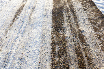 the snow-covered asphalt road close up
