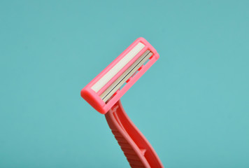 Plastic razor for depilation close-up on a blue background.