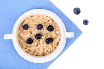 Healthy food. Oatmeal porridge with blueberries on blue napkin