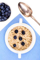 Healthy food. Oatmeal porridge with blueberries on blue napkin