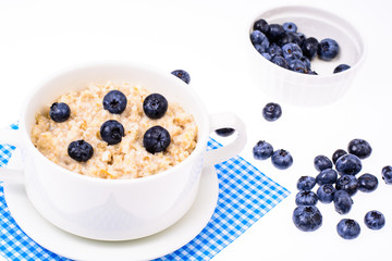 Healthy food. Oatmeal porridge with blueberries on blue napkin