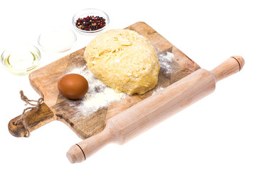 Ball of pizza dough on wooden kitchen cutting board with dusting of flour