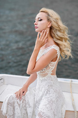 Fototapeta na wymiar Beautiful woman in a wedding dress. A woman in a boat on a marina