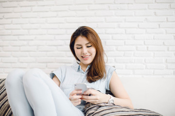 Happy young woman lying on couch and relaxing at home, casual style indoor shoot