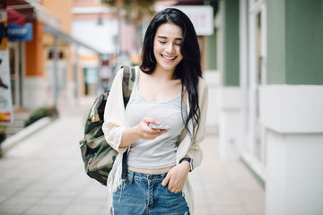 young Asian woman looking at mobile smartphone,shopping mall