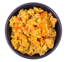 Rice with vegetables in black bowl on white background. View from above