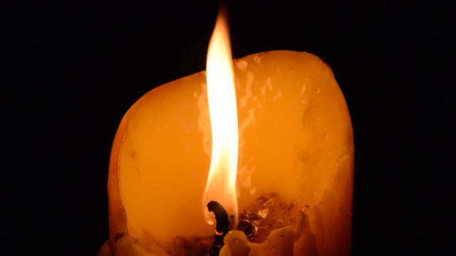 candle fire blowing from wind in the dark night