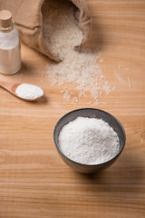 Fototapeta na wymiar Jasmine white rice in sack and rice flour on wooden table.