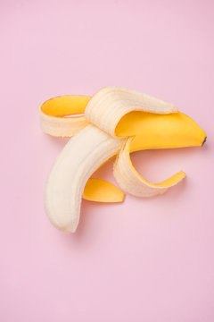 Detail of peeled banana on pink background