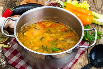 Vegetarian vegetable soup with eggplants and tomatoes in saucepan